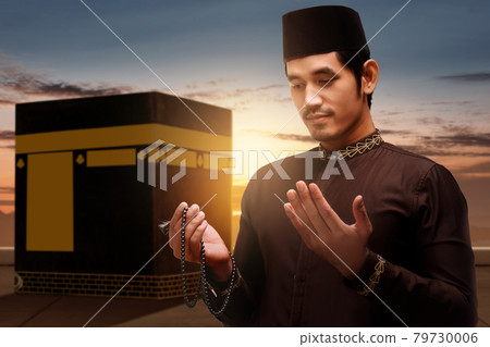 Asian Muslim man standing and praying with prayer beads with Kaaba view Asian Muslim man standing and praying with prayer beads with Kaaba view 79730006