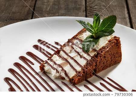 Slice of cheesecake on chocolate shortcrust pastry with poached pear 79730306