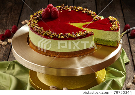Sliced pistachio cheesecake with raspberry jelly on cake stand Sliced pistachio cheesecake with raspberry jelly on cake stand 79730344