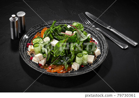 Goat cheese salad with persimmon, greens, cucumbers, pomegranate and walnuts Goat cheese salad with persimmon, greens, cucumbers, pomegranate and walnuts 79730361