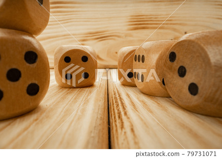 Wooden dice tossed on wooden background close up 79731071