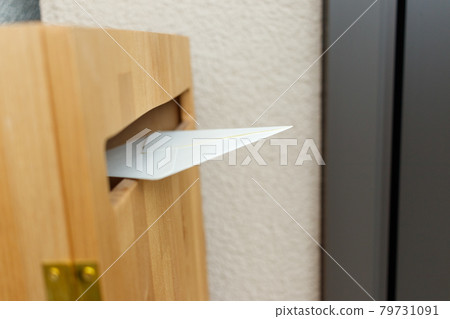 A letter posted on a wooden mailbox next to the entrance A letter posted on a wooden mailbox next to the entrance 79731091