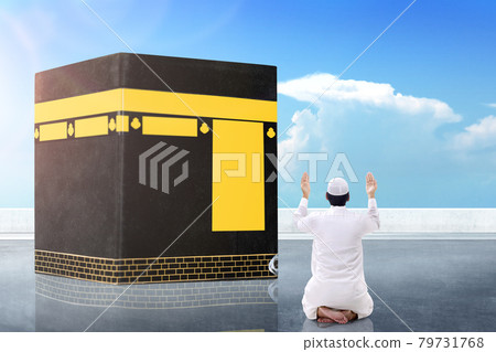 Rear view of Asian Muslim man sitting and praying in front of the Kaaba Rear view of Asian Muslim man sitting and praying in front of the Kaaba 79731768