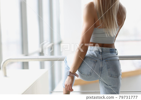 Fitness bracelet putting on hand of young woman back view 79731777