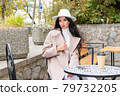 Portrait of a woman at cafe table 79732205