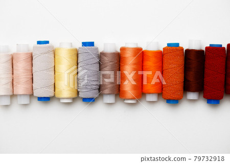 Colored spools of threads on white background 79732918