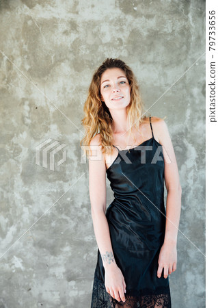 portrait of a beautiful woman in a black dress on a gray background portrait of a beautiful woman in a black dress on a gray background 79733656