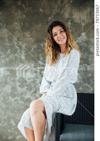 portrait of a beautiful fashionable woman in a light dress on the loft sofa portrait of a beautiful fashionable woman in a light dress on the loft sofa 79733667
