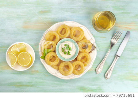 Squid rings with mayonnaise, lemons, and a glass of white wine Squid rings with mayonnaise, lemons, and a glass of white wine 79733691