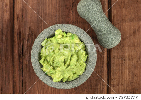 A photo of guacamole sauce in a molcajete, traditional Mexican bowl 79733777
