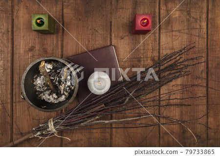 Overhead photo of cauldron, grimoire, candles, and a broom 79733865