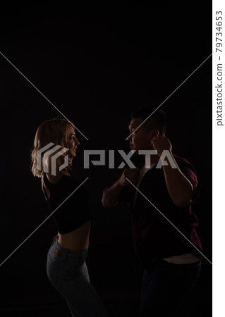 a man and a woman dance together to music in the dark 79734653