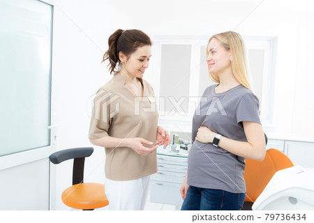positive pregnant woman in dentist office, consultation with young woman dentist. dental treatment for pregnant women 79736434