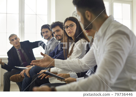Group of people sitting in row, communicating and listening to each other's opinions Group of people sitting in row, communicating and listening to each other's opinions 79736446