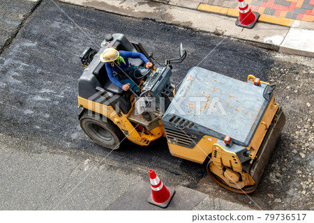 Asphalt paved road repair work 79736517