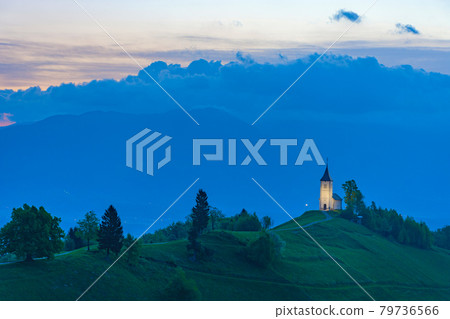Charming little St. Primus and Felician church in Jamnik, Julian Alps, Slovenia and beautiful sunrise sky colors 79736566