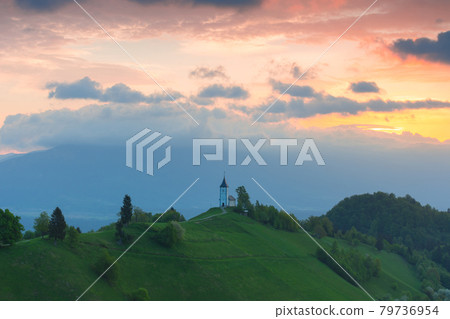 Charming little St. Primus and Felician church in Jamnik, Julian Alps, Slovenia and beautiful sunrise sky colors 79736954