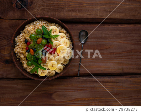 Wholegrain Oatmeal porridge bowl with fresh berries, fruits, nuts mint leaves flat lay. Healthy food oat meal breakfast Wholegrain Oatmeal porridge bowl with fresh berries, fruits, nuts mint leaves flat lay. Healthy food oat meal breakfast 79738275