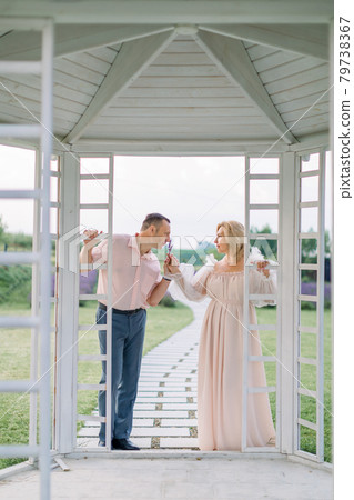 Happy pleasant mature couple in love, standing together outdoors and enjoying the scent of lavender Happy pleasant mature couple in love, standing together outdoors and enjoying the scent of lavender 79738367