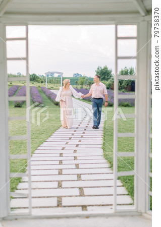 beautiful middle aged couple, handsome man and charming woman, walking holding hands on path beautiful middle aged couple, handsome man and charming woman, walking holding hands on path 79738370