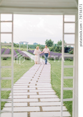 beautiful middle aged couple, handsome man and charming woman, walking holding hands on path beautiful middle aged couple, handsome man and charming woman, walking holding hands on path 79738371