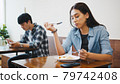Young Asian man and woman having lunch meal in local restaurant, sit in social distance 79742408