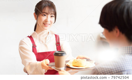 咖啡館的一位女店員在櫃檯向顧客下訂單 79742504
