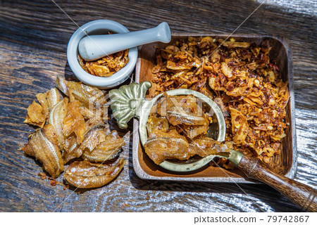Dried chilli paste with crispy fish thai style or Crispy fish chilli paste in ceramic white cup on wooden table. Dried chilli paste with crispy fish thai style or Crispy fish chilli paste in ceramic white cup on wooden table. 79742867