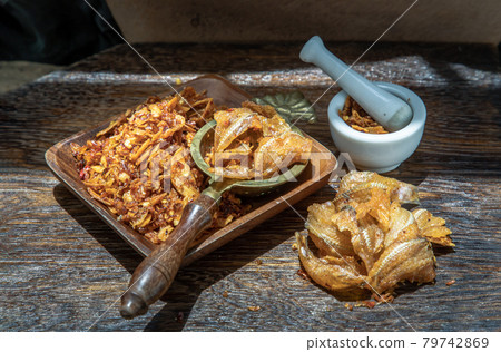 Dried chilli paste with crispy fish thai style or Crispy fish chilli paste in ceramic white cup on wooden table. 79742869