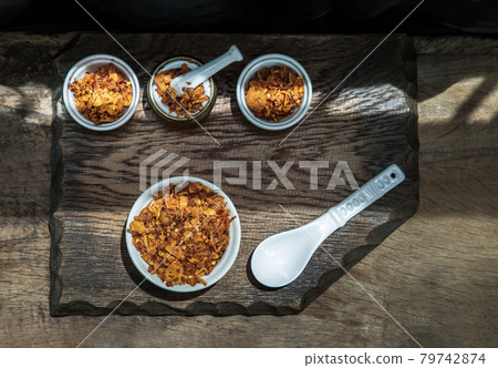 Dried chilli paste with crispy shrimp thai style or Crispy shrimp chilli paste in ceramic white cup on old wooden table. Dried chilli paste with crispy shrimp thai style or Crispy shrimp chilli paste in ceramic white cup on old wooden table. 79742874