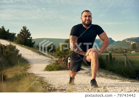 Male athlete warming up before start running in mountains 79743442