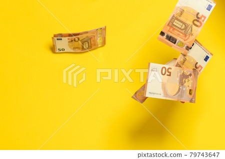 Rain of euro bills, flying falling money on a yellow background, European currency in the face of fifty euros. Rain of euro bills, flying falling money on a yellow background, European currency in the face of fifty euros. 79743647