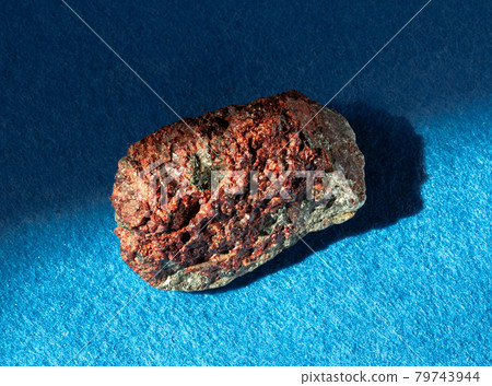 Garnet almandine stone crystal inside rock. A mineral isolated on blue background. Found near Miass city, Ural, Russia. Geology mineralogy websites, stone collection catalog etc Garnet almandine stone crystal inside rock. A mineral isolated on blue background. Found near Miass city, Ural, Russia. Geology mineralogy websites, stone collection catalog etc 79743944