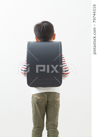 Elementary school student carrying a school bag 79744319