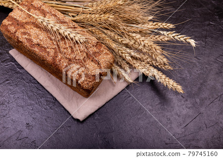 Loaf of whole grain bread and shocks of wheat. Rustic sourdough bread 79745160
