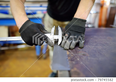 Metalwork craftsman working with metal at workshop. Man using caliper. Diy. Small local business. Metalwork craftsman working with metal at workshop. Man using caliper. Diy. Small local business. 79745582