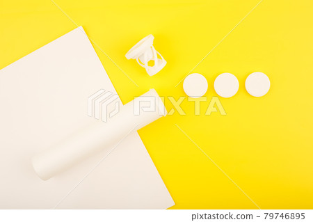 Creative flat lay with opened tube with effervescent vitamins on white and yellow background Creative flat lay with opened tube with effervescent vitamins on white and yellow background 79746895