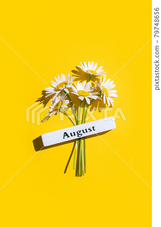 Calendar summer month August and chamomile flowers on yellow background. Top view Flat lay. Minimal concept Hello August. Template for your design, greeting card 79748656