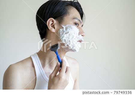 A man shaving his beard 79749336