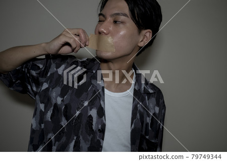 A man with a gum tape on his mouth 79749344