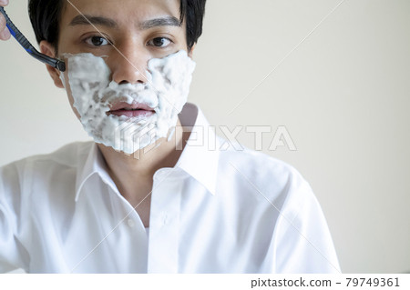A man shaving his beard 79749361
