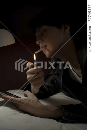 Man smoking in bed 79749385
