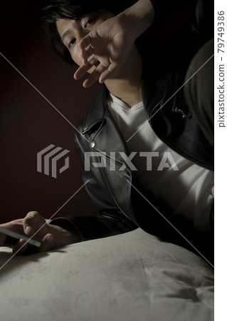 Leather jacket man looking at a smartphone 79749386