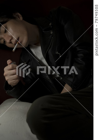 Leather jacket man smoking a cigarette 79749388