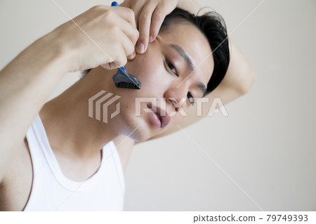 A man shaving his beard A man shaving his beard 79749393
