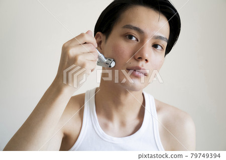 A man shaving his beard A man shaving his beard 79749394