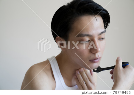 A man shaving his beard A man shaving his beard 79749495