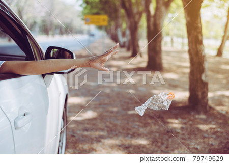 Woman hand throwing plastic bottle trash on the road,Environment and pollution campaign concept Woman hand throwing plastic bottle trash on the road,Environment and pollution campaign concept 79749629