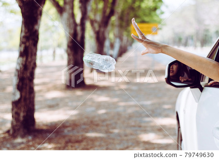 Woman hand throwing plastic bottle trash on the road,Environment and pollution campaign concept Woman hand throwing plastic bottle trash on the road,Environment and pollution campaign concept 79749630