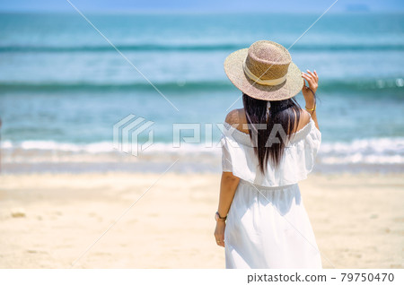 A woman standing on the beach 79750470